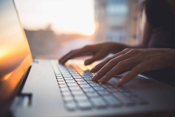 Photo of hands on a laptop keyboard